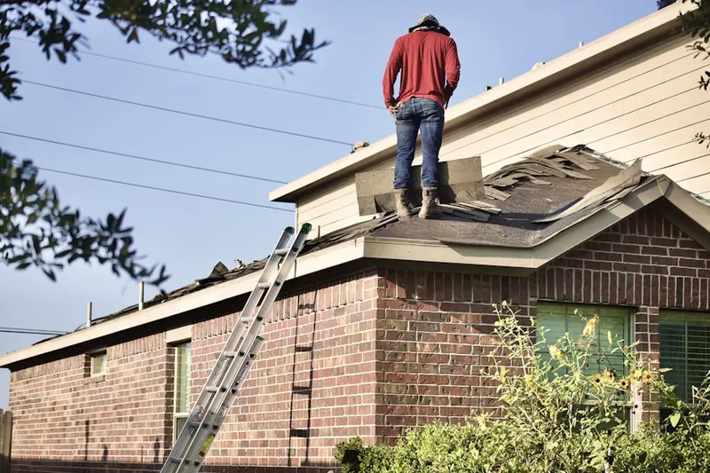 Professional roofer working on a residential roof in Hunt Meadows